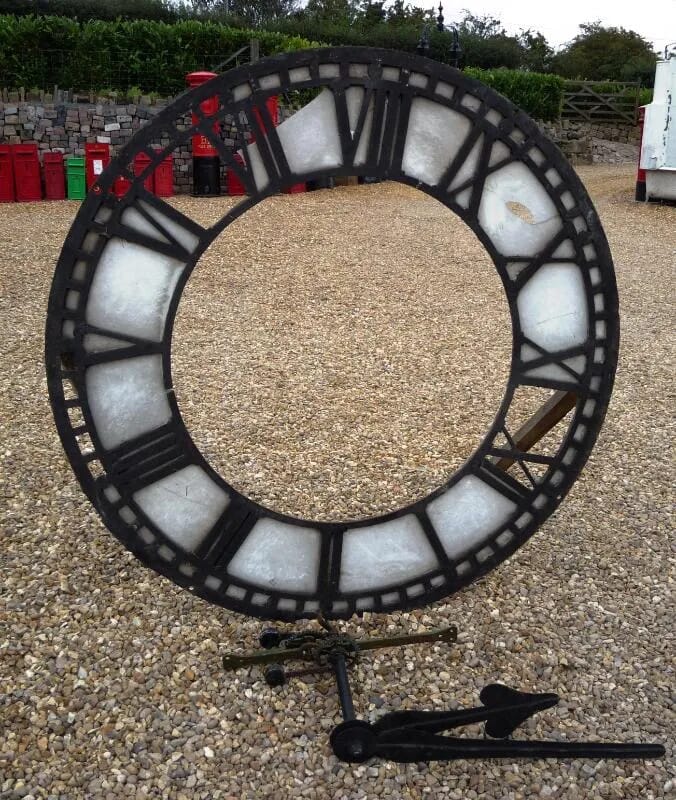 An antique cast iron clock face with hands - 4236