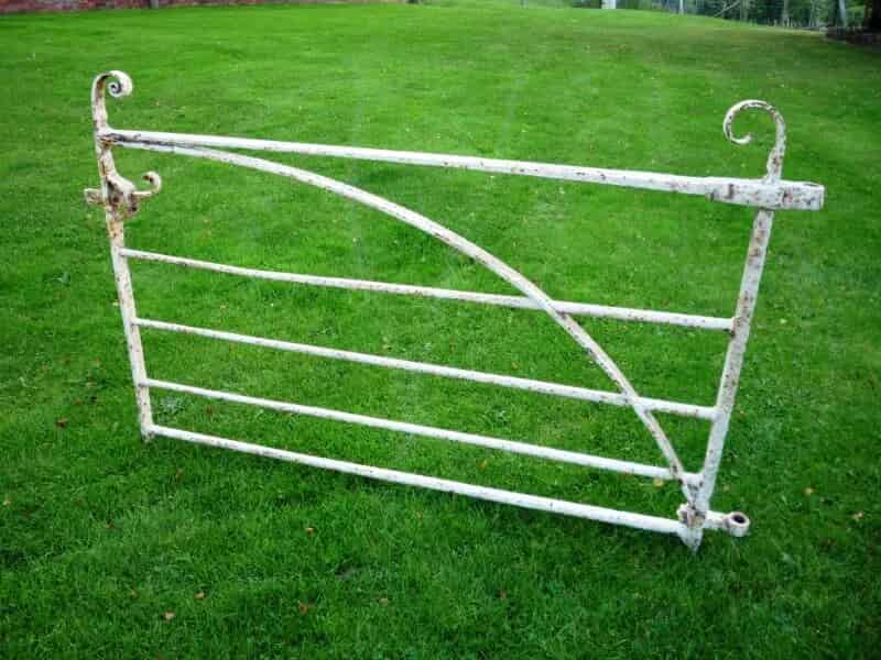 A pair of wrought iron gates with cast iron posts