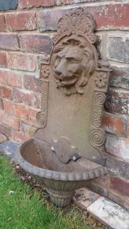 A Victorian cast iron wall mounted Lion water fountain