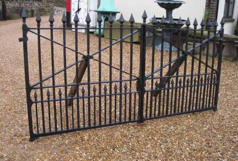 A pair of Antique wrought iron gates with cast iron finials